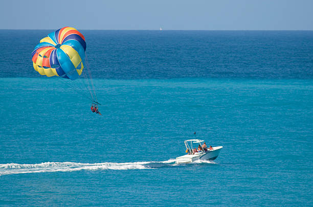 Vacationers Try Out The Water Sport Of Parasailing